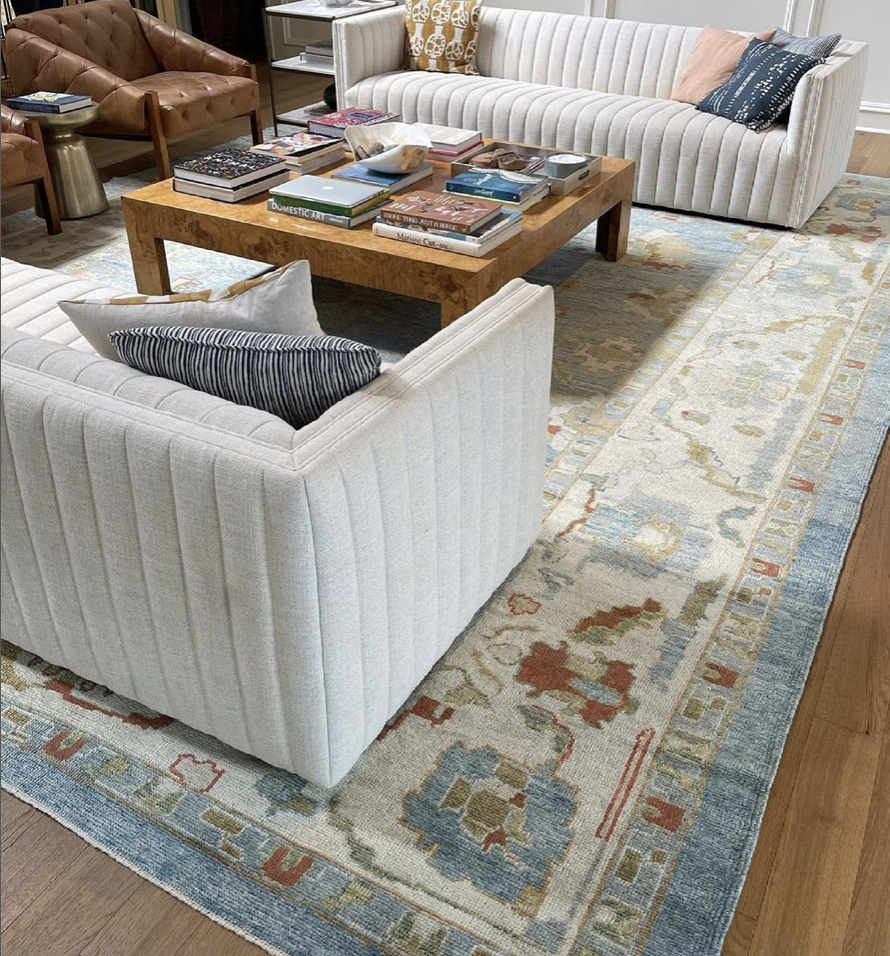 Turkish rug in living room with blue. cream, Burgundy and neutral colors.