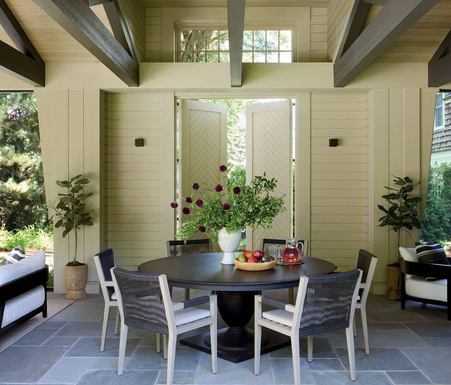 traditional, cozy covered porch with a dining set