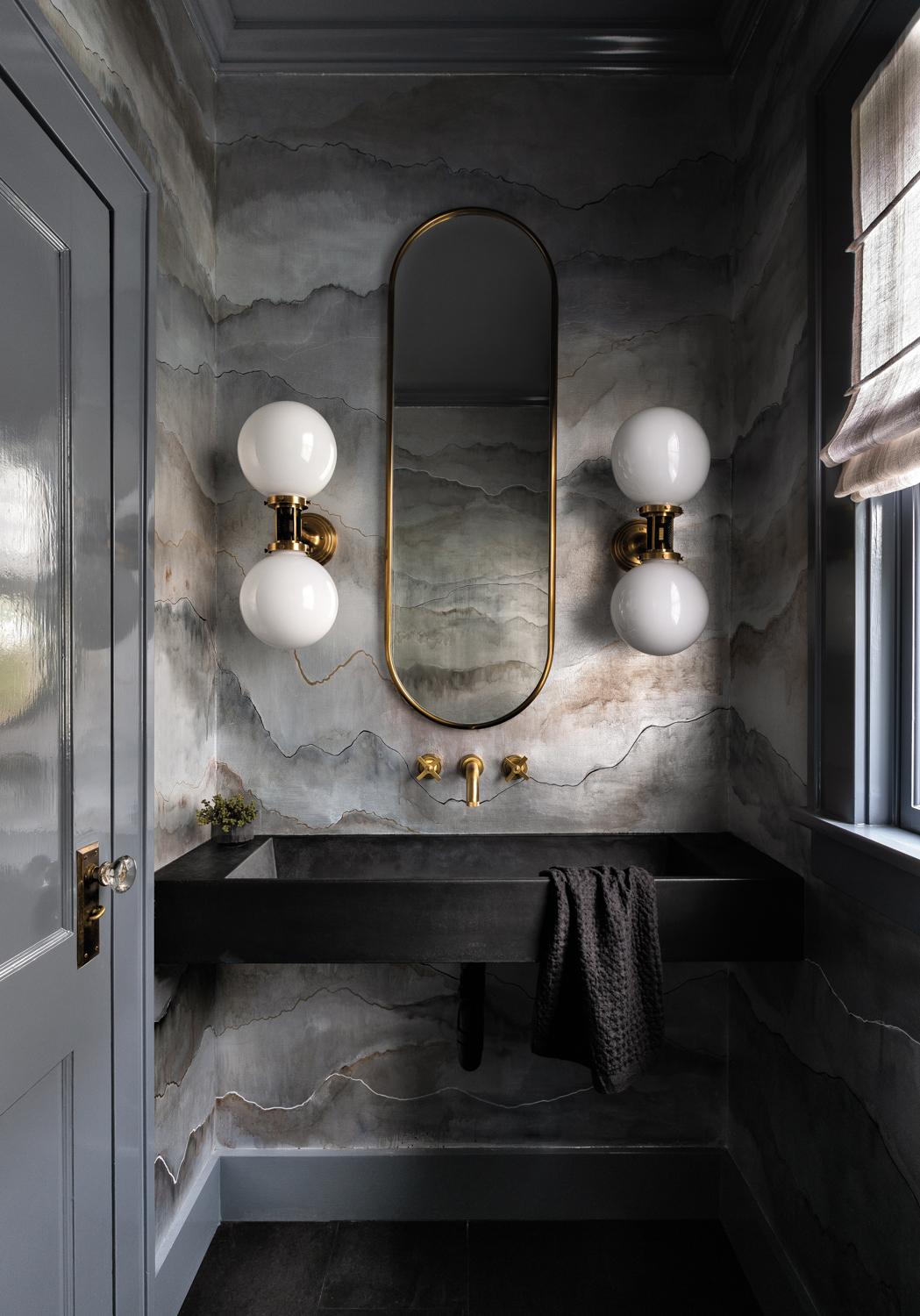 A powder room has a textured wallpaper.