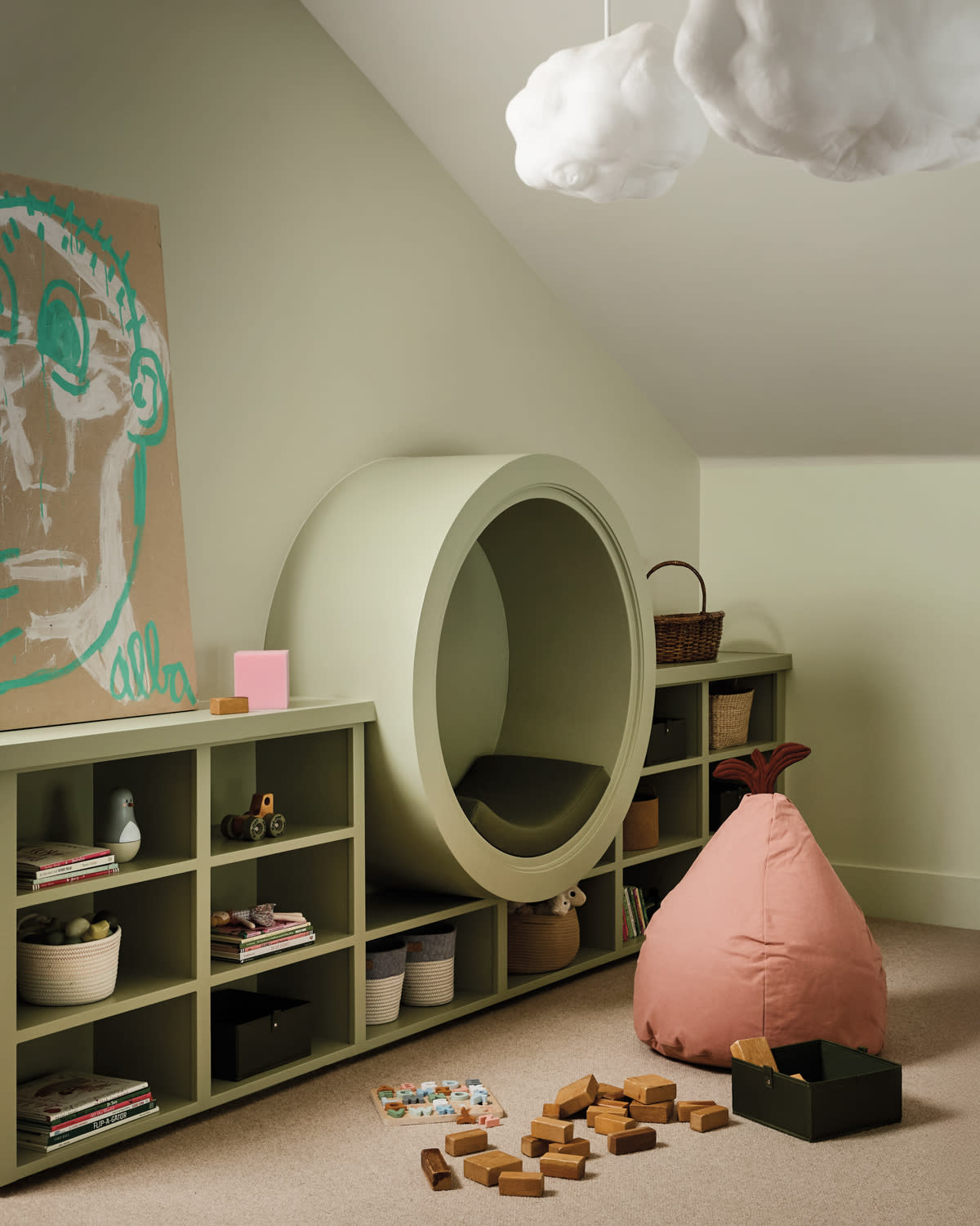 Cozy playroom with pastel tones. Features a circular reading nook, cloud-shaped lights and wooden toys