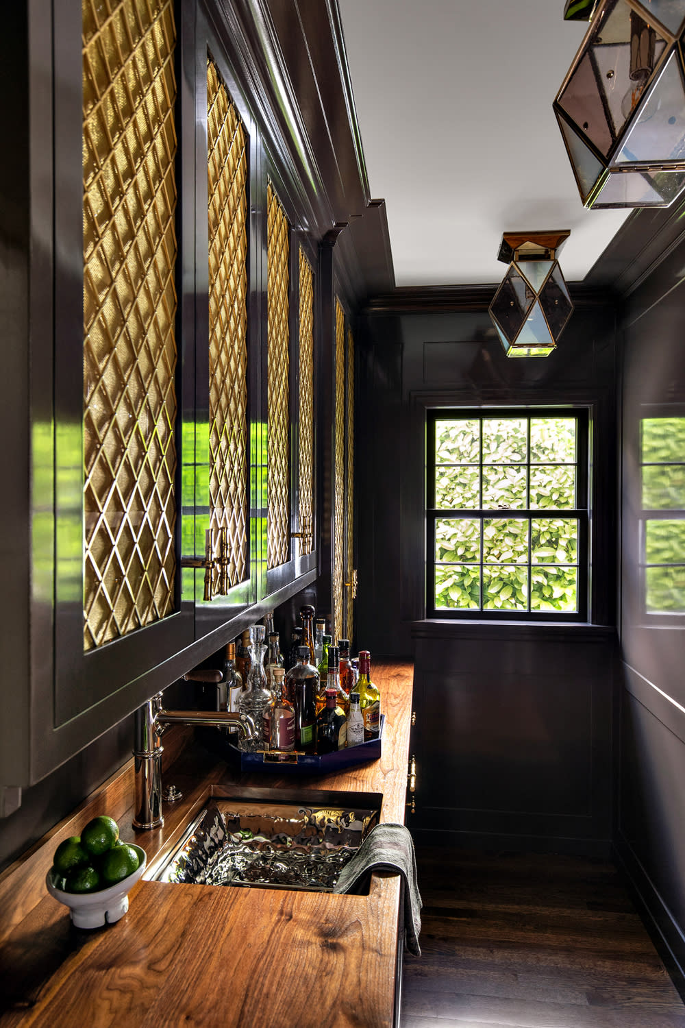 moody dark pantry with a walnut counter and a hammered-nickel sink