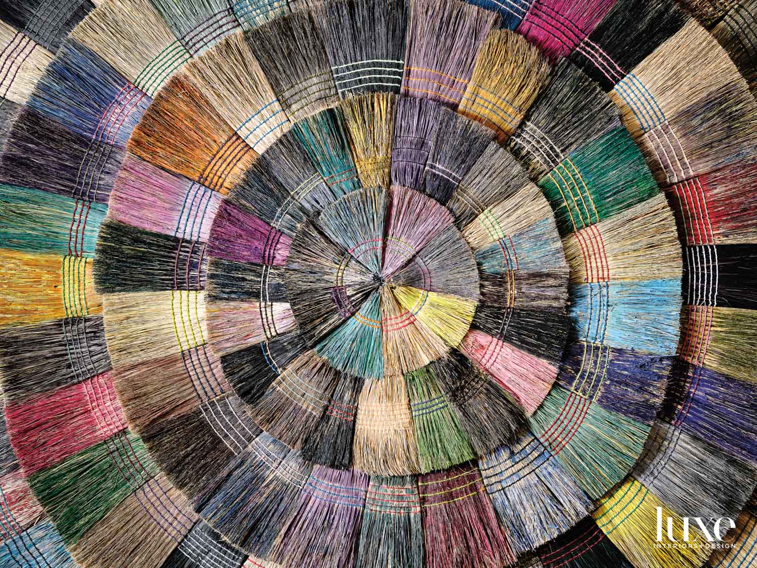 Painted brooms are composed into artwork.