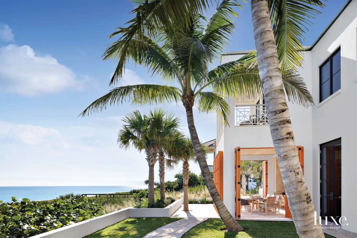 Georgian architecture exterior with stucco walls and coconut palms in home by Peter Moor