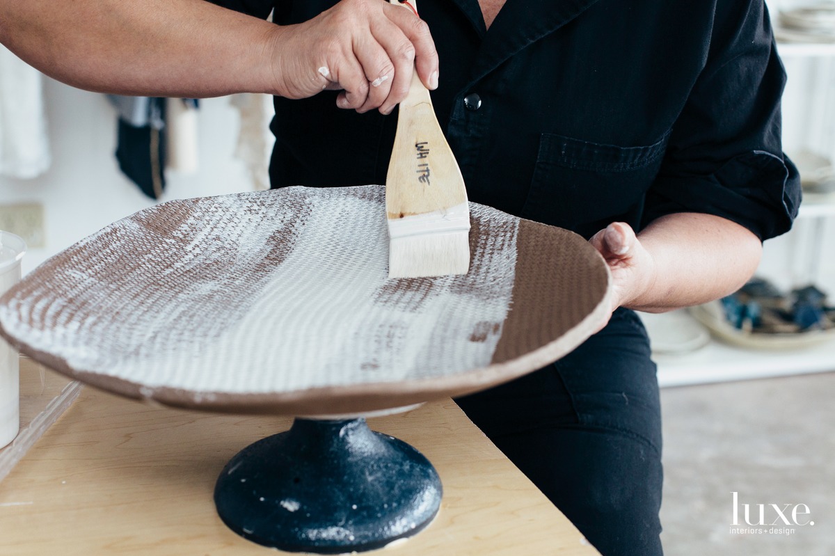 Madison applies glaze to a footed platter.