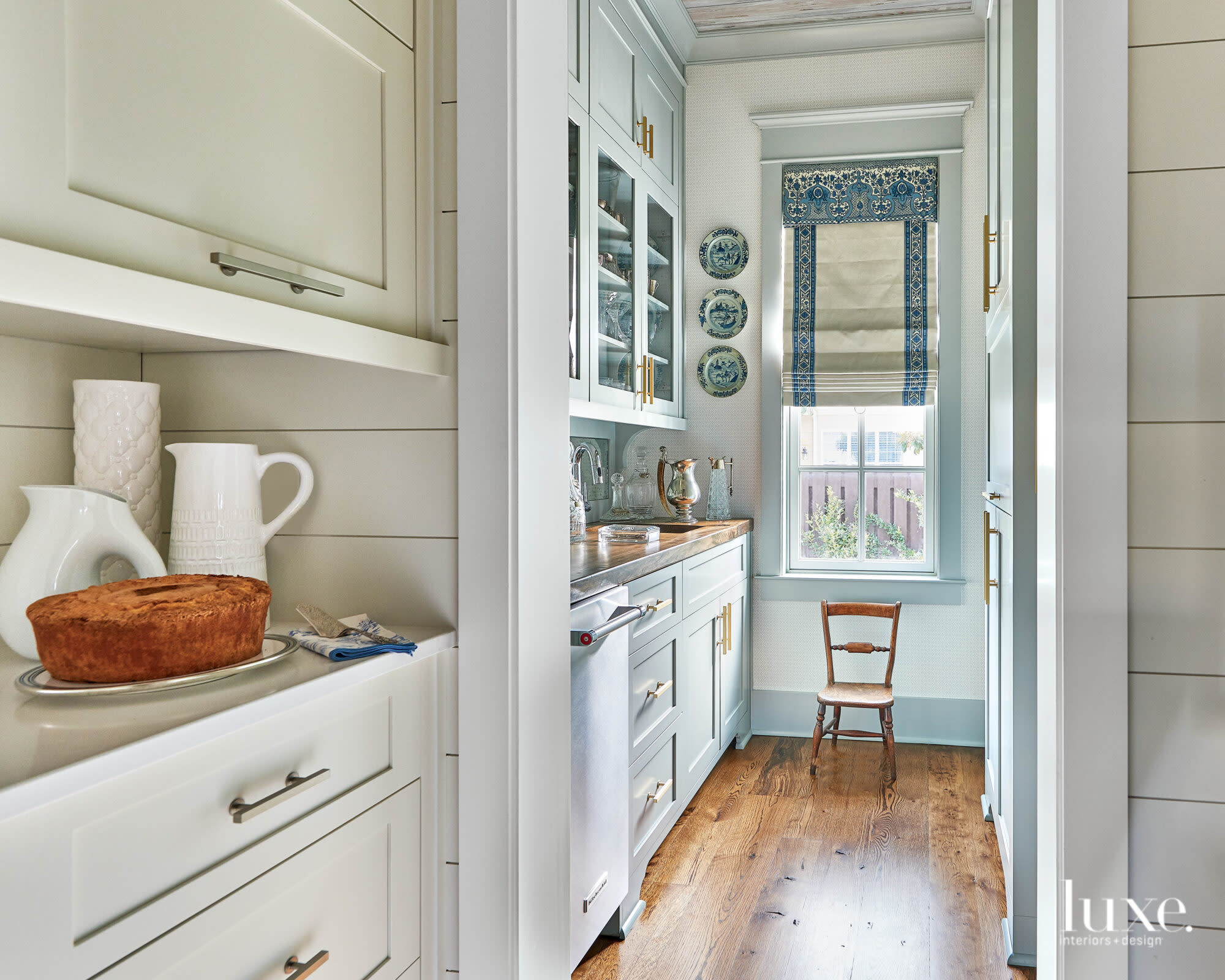 A kitchen service area featuring a prep sink, wood floors and light blue walls