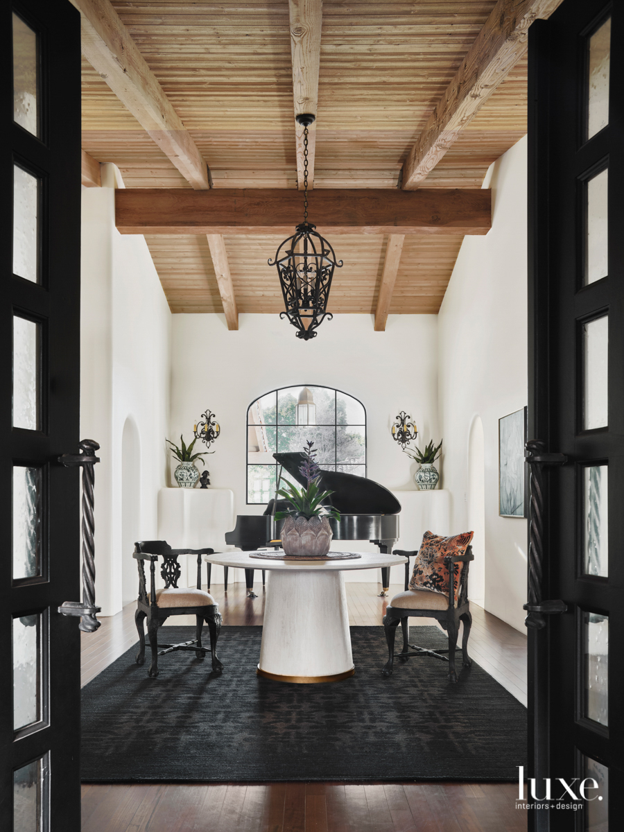 The black-and-white-dominated entry way where the natural ceiling beams take center stage.