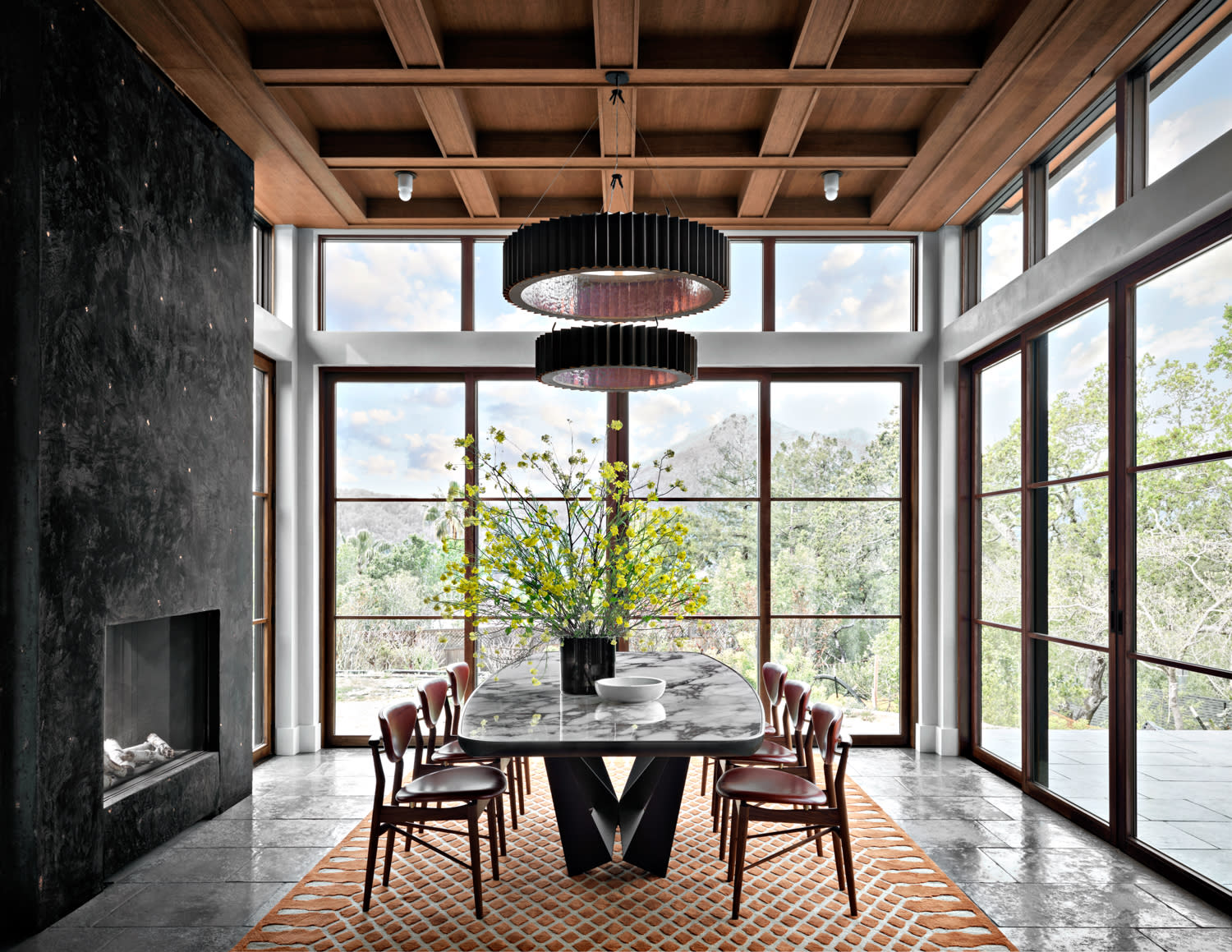 midcentury modern furnishings fill this dining room with floor-to-ceiling glass walls