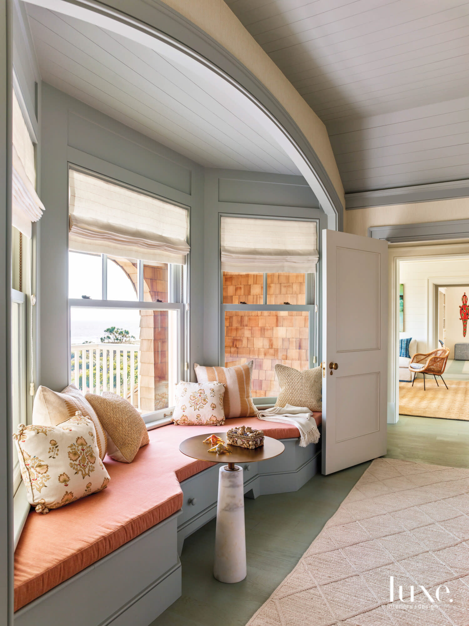 Bay window seat with coral cushion and small side table