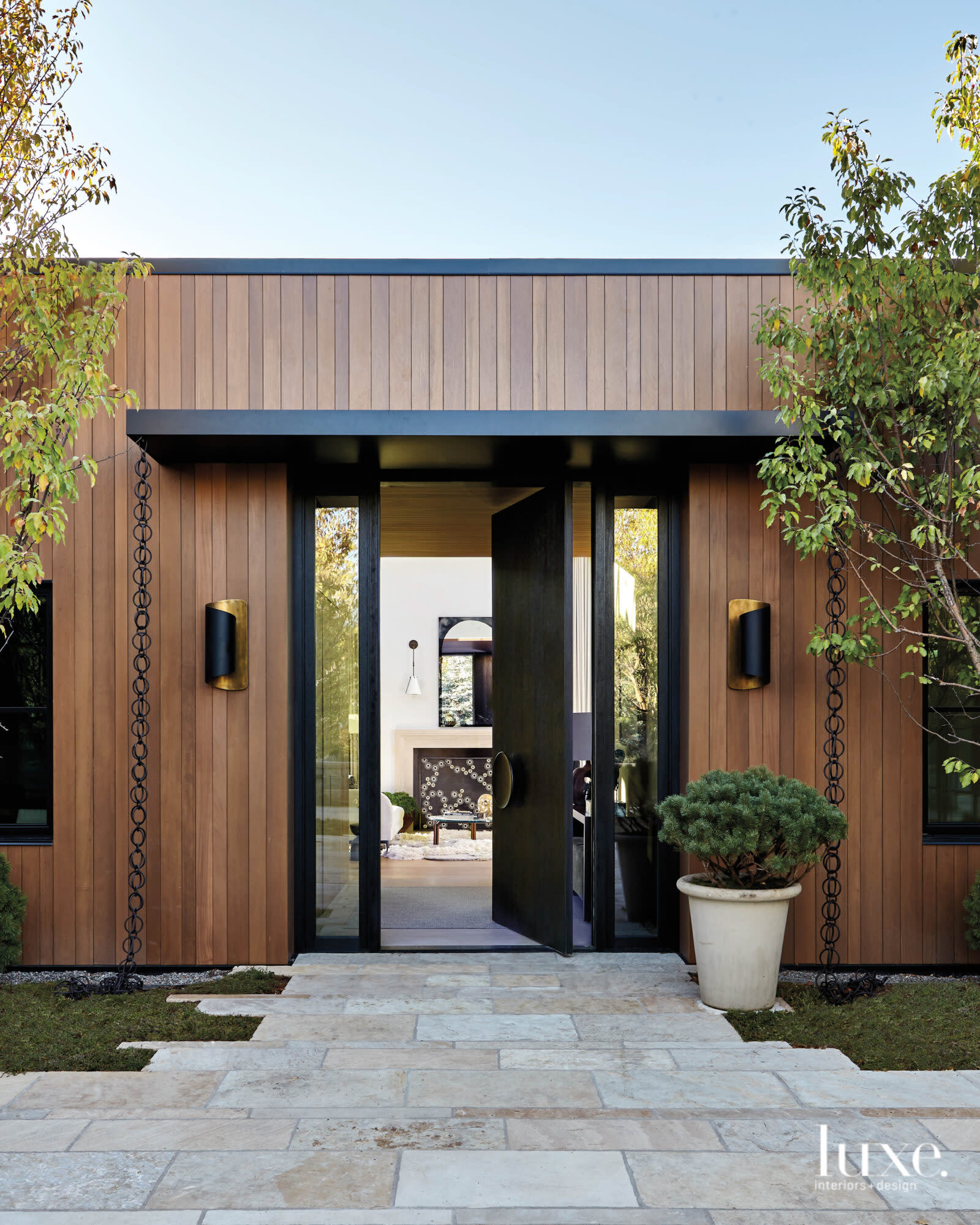The exterior of the house is covered with vertical wood panels.