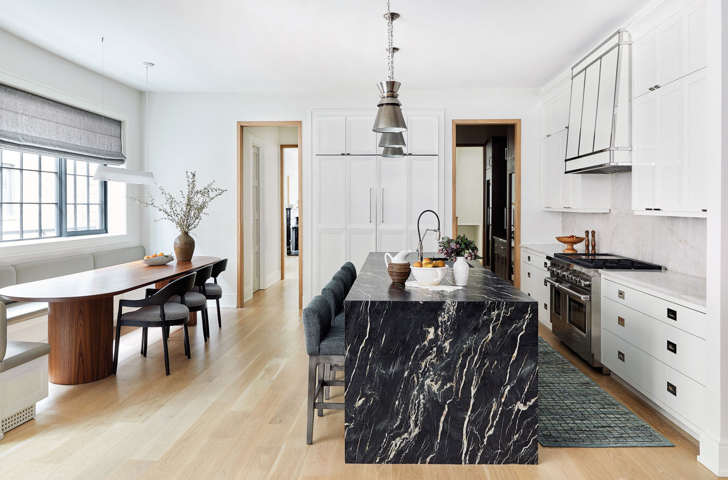 kitchen with black marble island and built-in banquette with long oval wood table