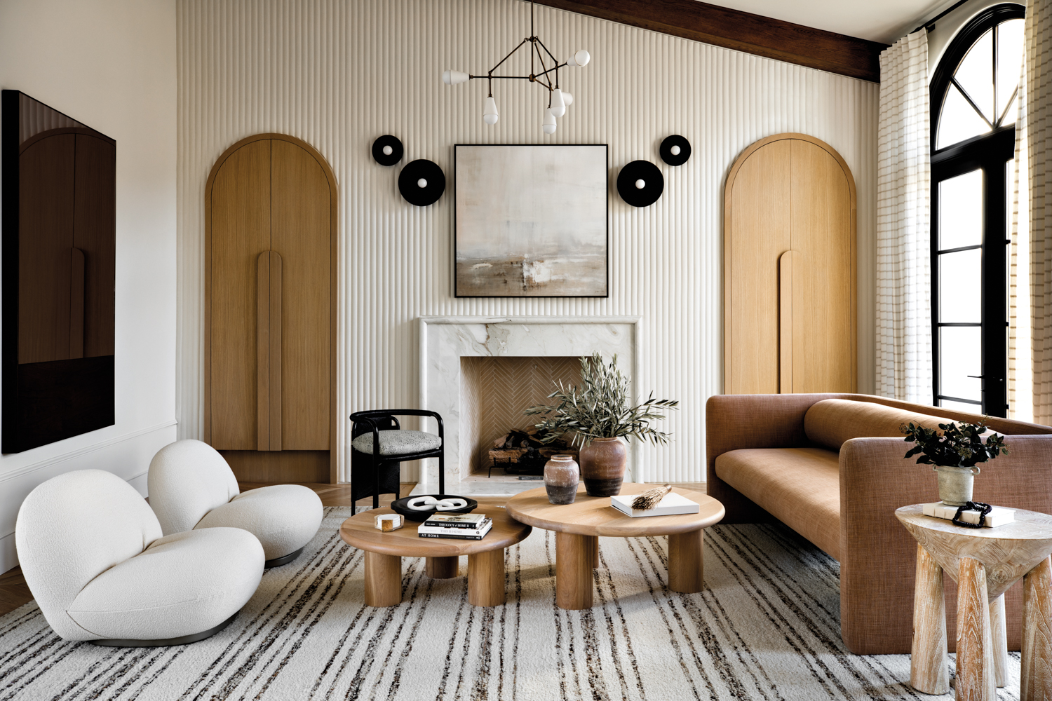 Living room with white raked-plaster walls, arched built-ins and a marble fireplace