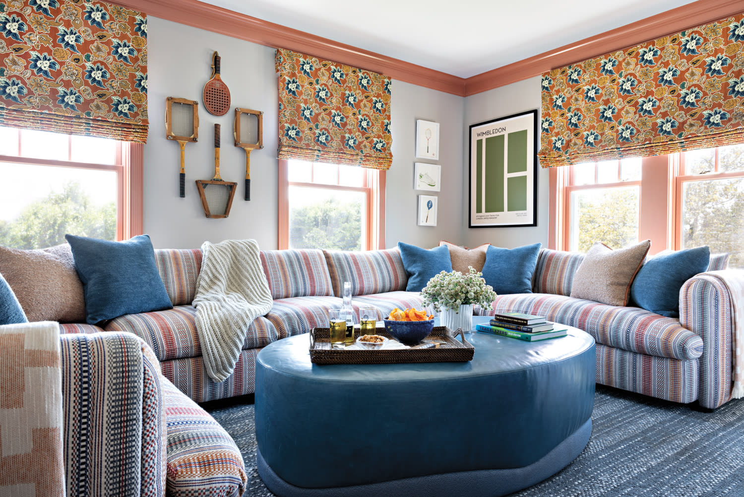 family room with tennis racket artwork, striped sofas, and floral patterned curtains