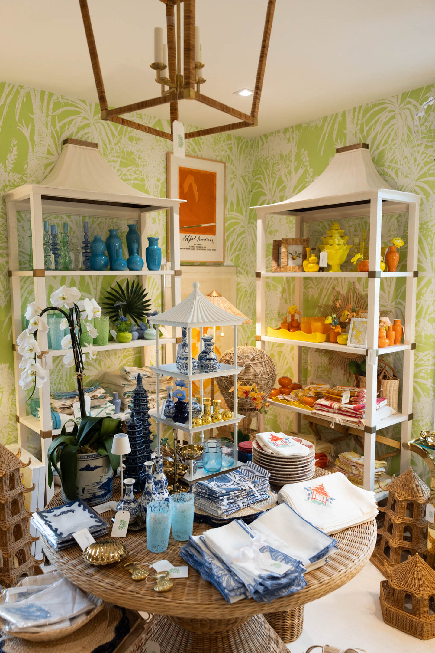 A vibrant, tropical-themed store display with green leaf-patterned wallpaper. 
