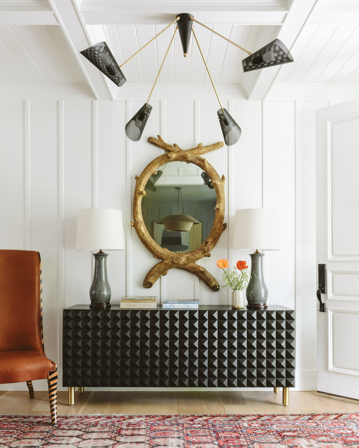 rustic mirror above a black console in an entryway