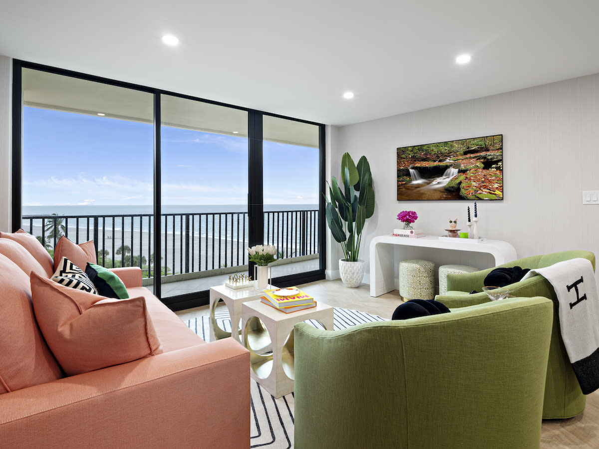 Living room overlooking water with colorful seating.