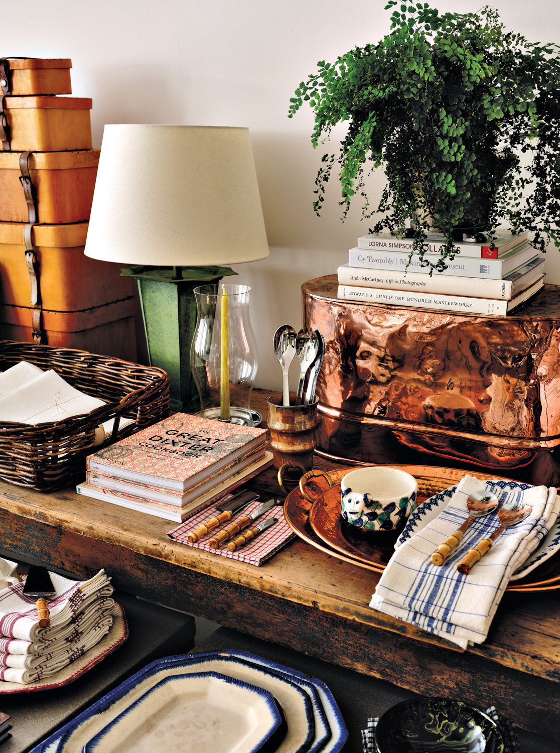 detail shot of home decor items at McGrath II shop, including tableware, books and a green lamp with white shade