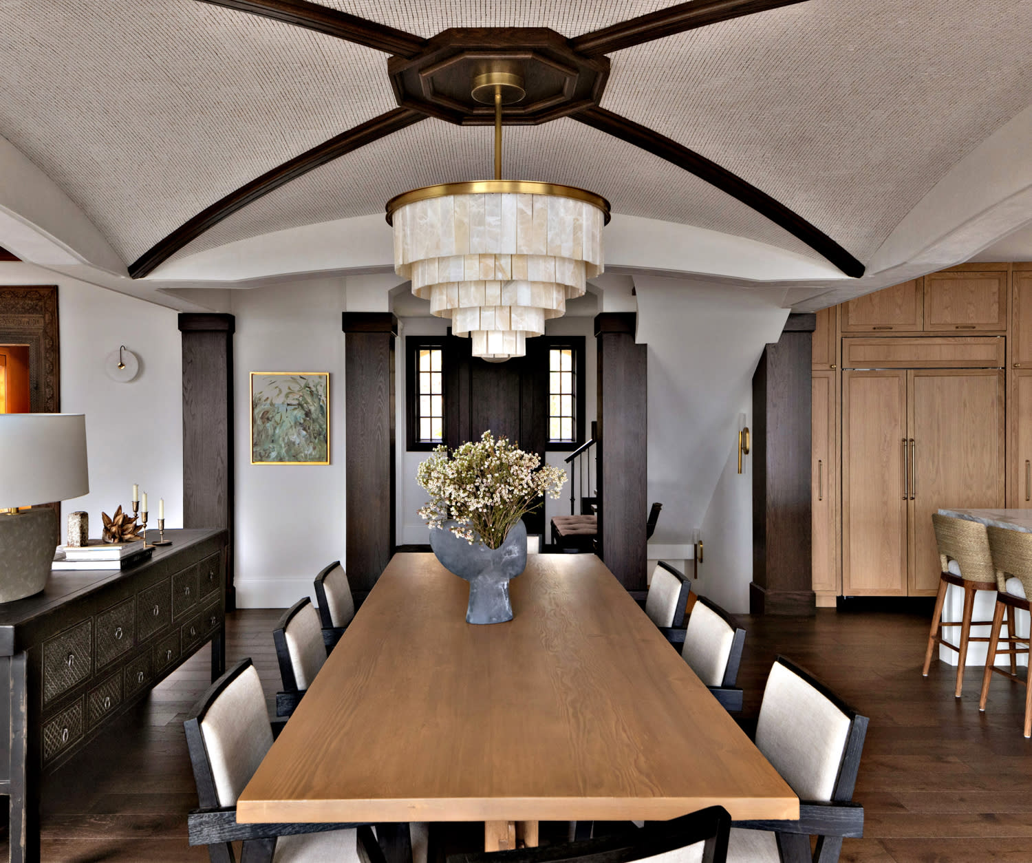 dining table in a Mediterranean modern home topped with a tiered light fixture