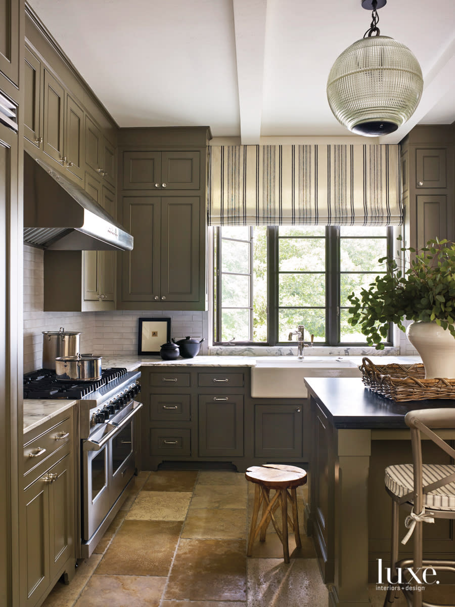 kithen with backsplash tiles, metal stools and gold perimeter countertops