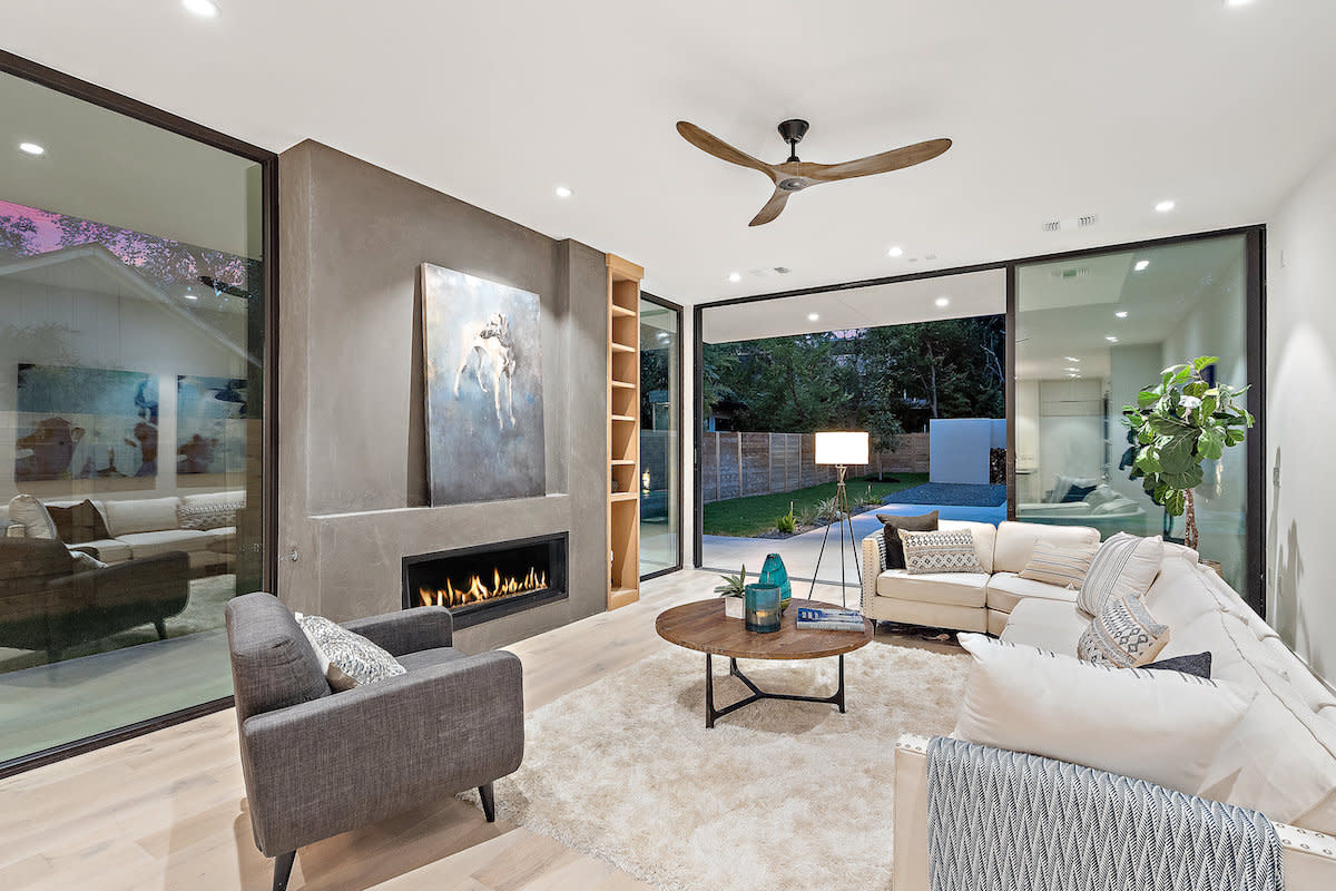 A contemporary living room with a fireplace and glass doors, offering a cozy and stylish ambiance.