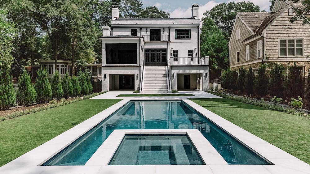 Custom hardscape design with oyster pavers and modern finish surrounding a custom pool by Firerock