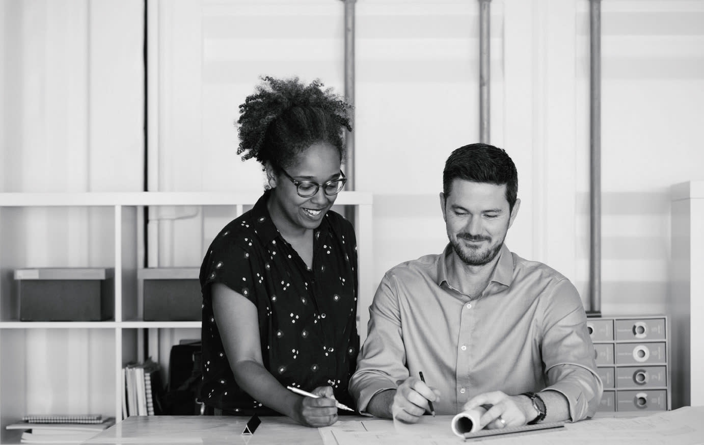 A woman and man drawing together at a desk