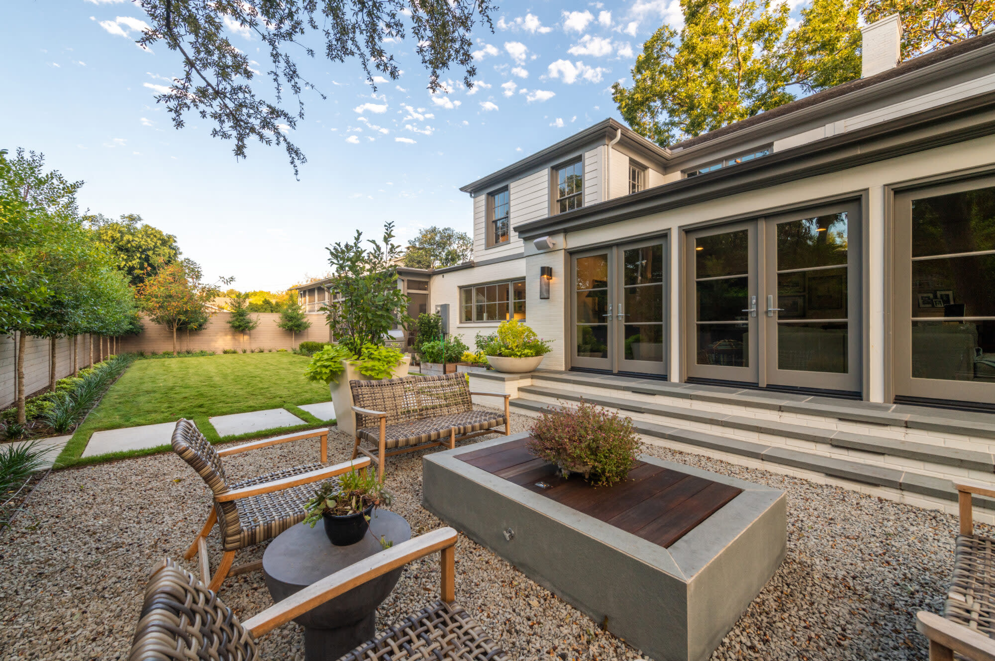 Expansive patio with fire pit and gravel detail outside a contemporary home