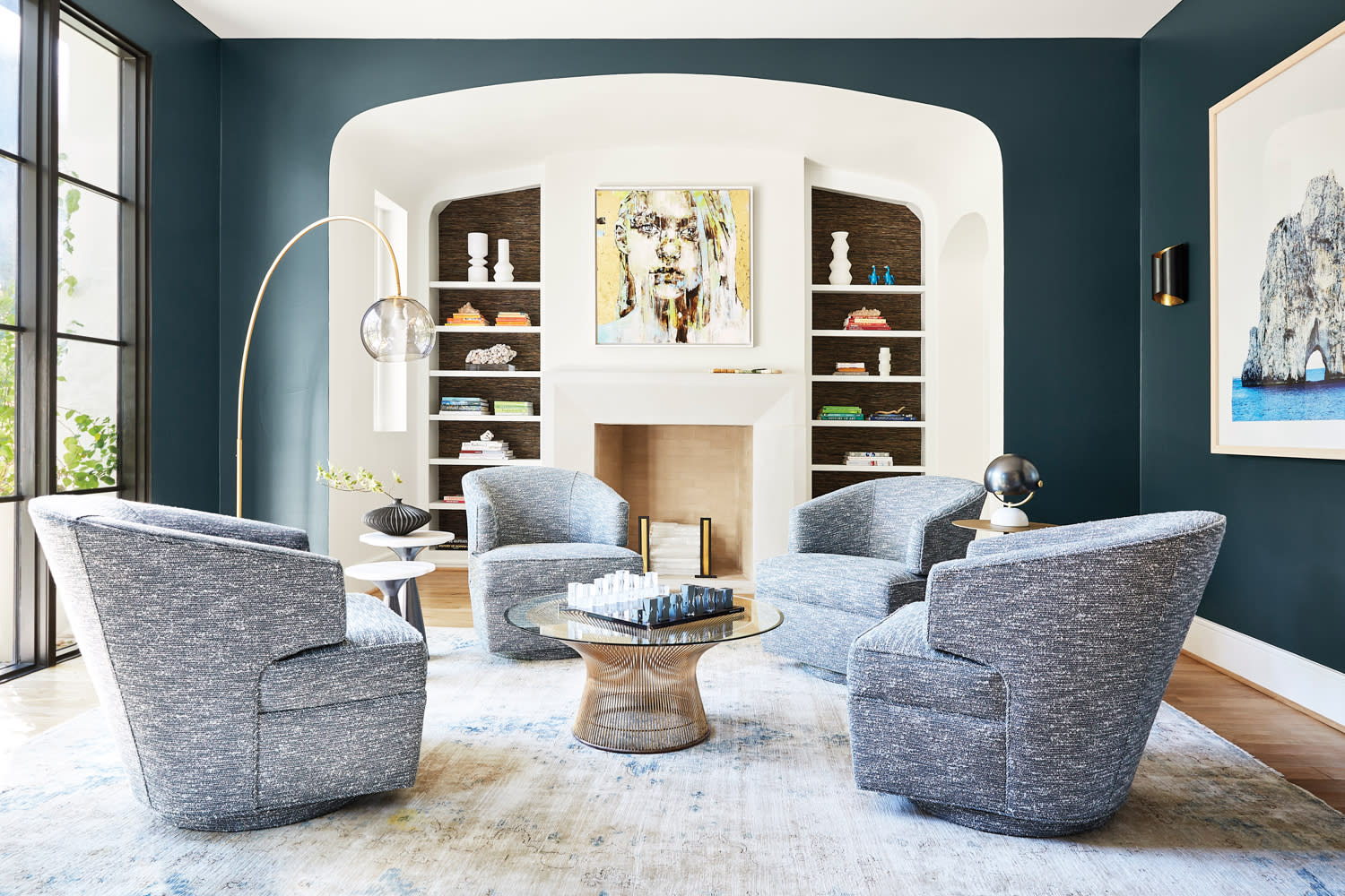 Living room centered by white stone fireplace surround flanked by built-ins