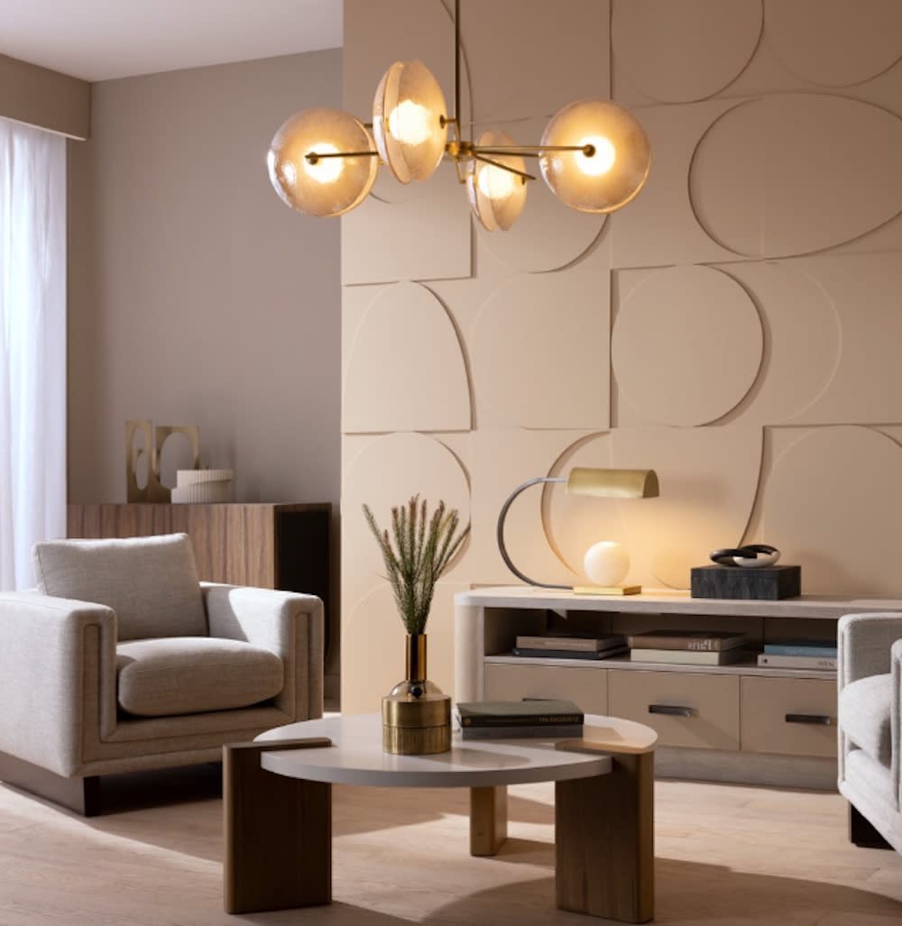 Living room with elegant chandelier, circular coffee table, and plush chairs against a stylish feature wall.