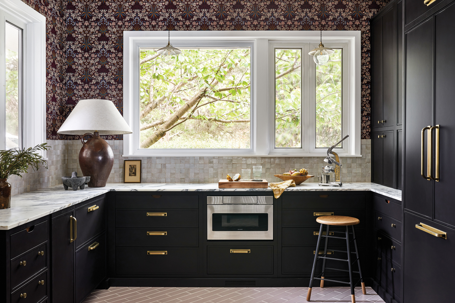 Black kitchen cabinetry with brass hardware