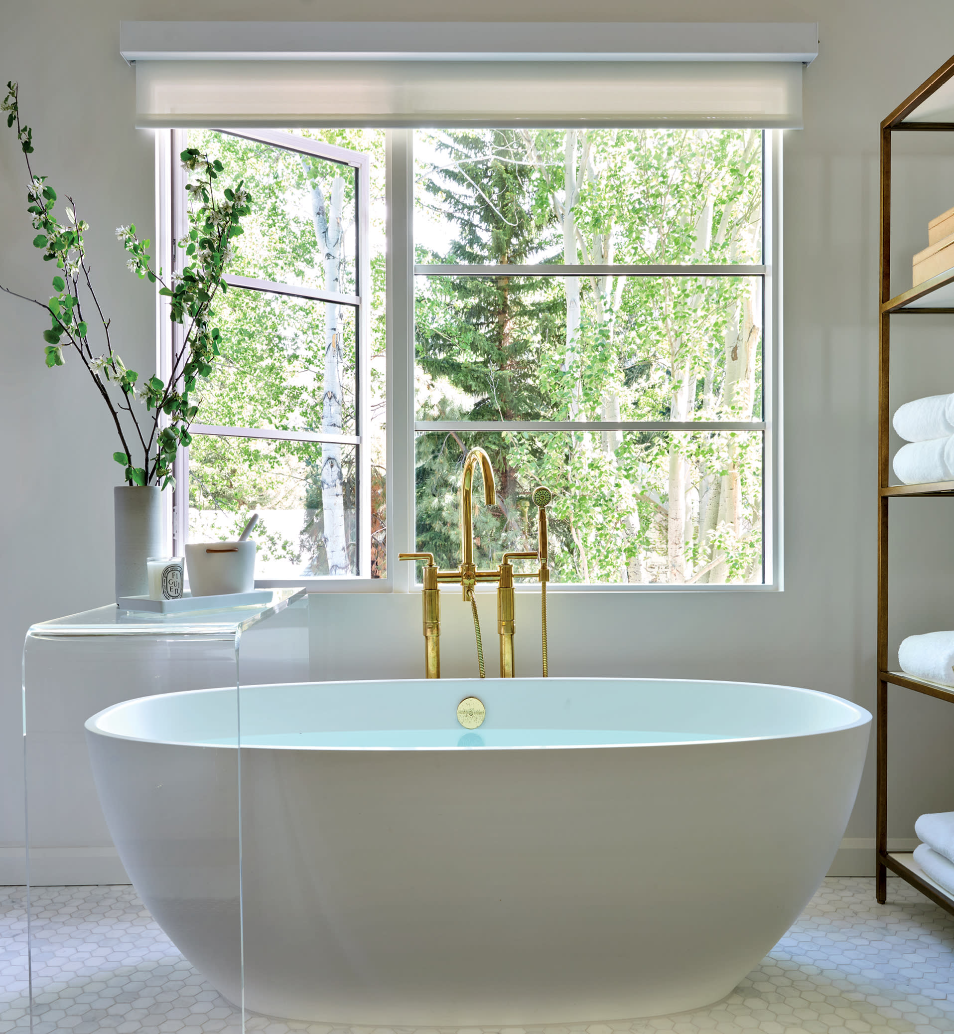 clean and contemporary bathroom with a Victoria + Albert soaking tub fitted with gold hardware