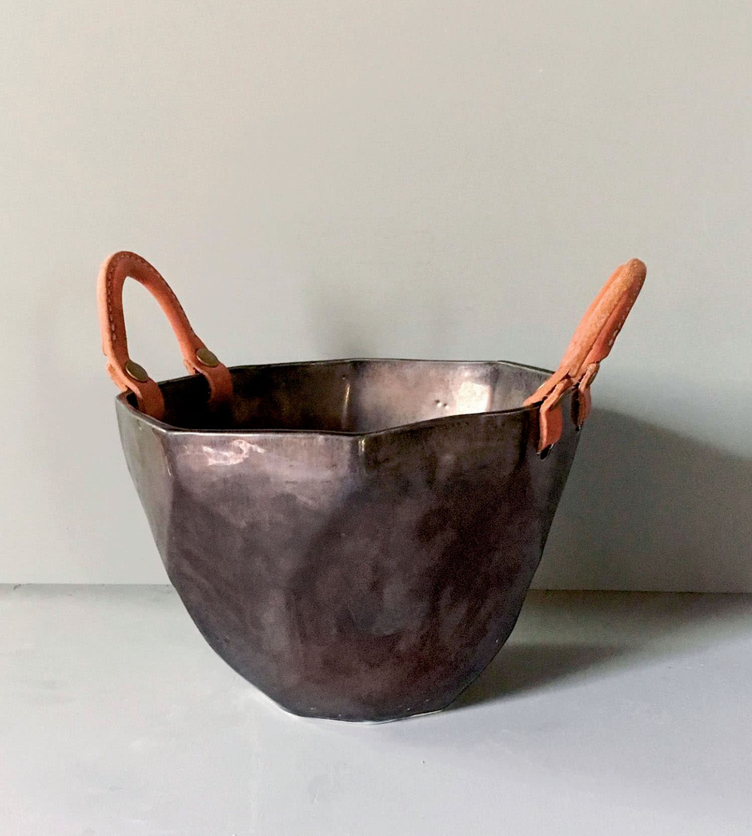 An ice bucket with leather handles.
