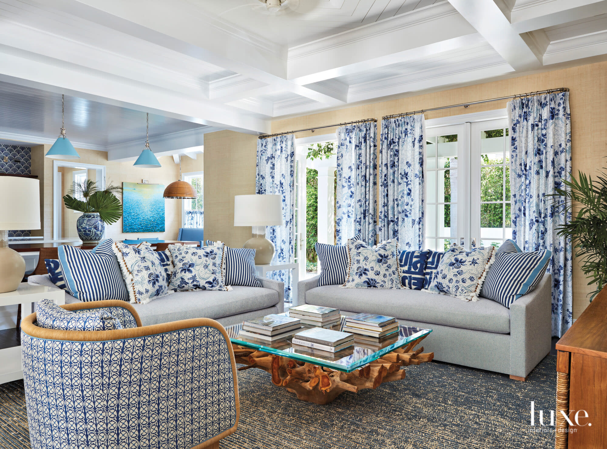 Family area with blue patterned armchairs, billows and draperies.