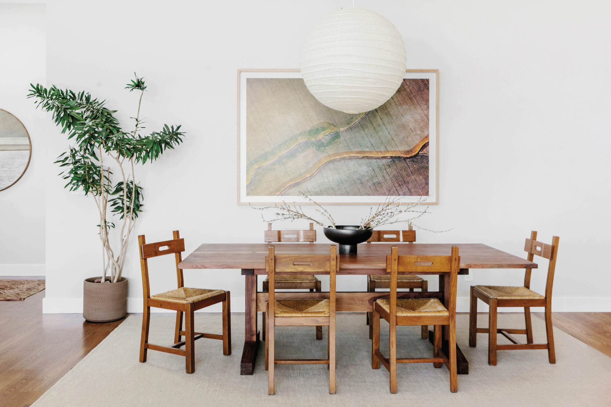 table with artwork and big globe pendant hanging above