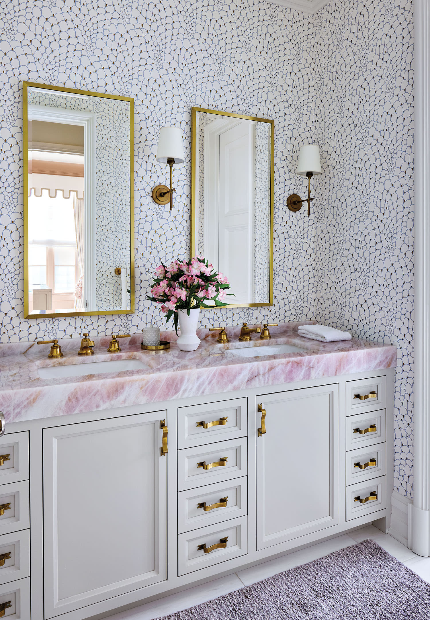 contemporary girl's bathroom with a pink-and-white stone countertop above a white vanity