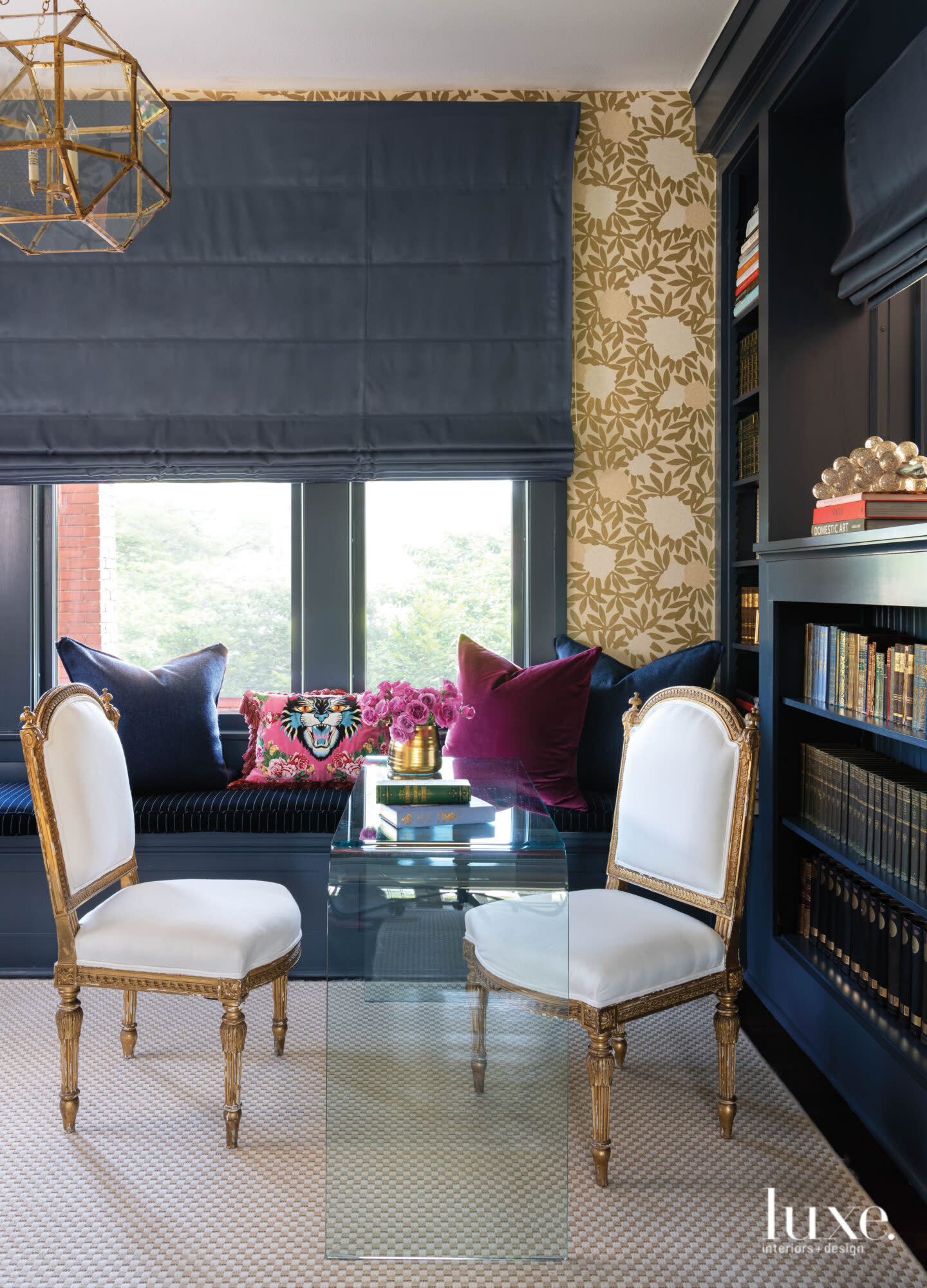 Study with navy walls and a pair of white chairs