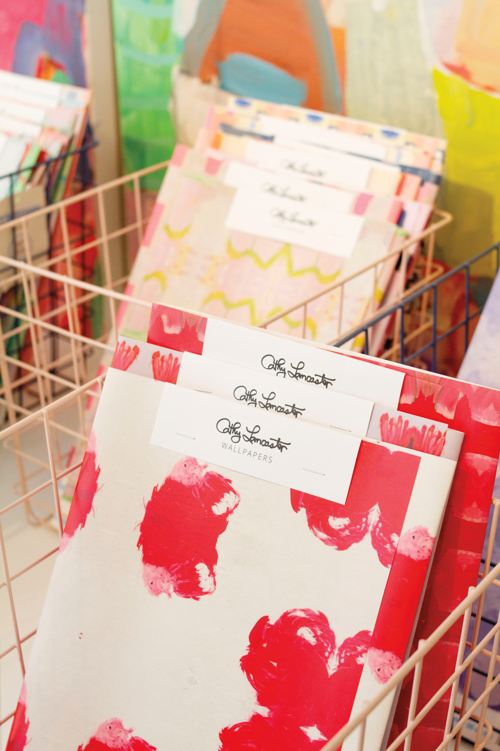 Samples of red-and-white collage wallcovering in a basket.