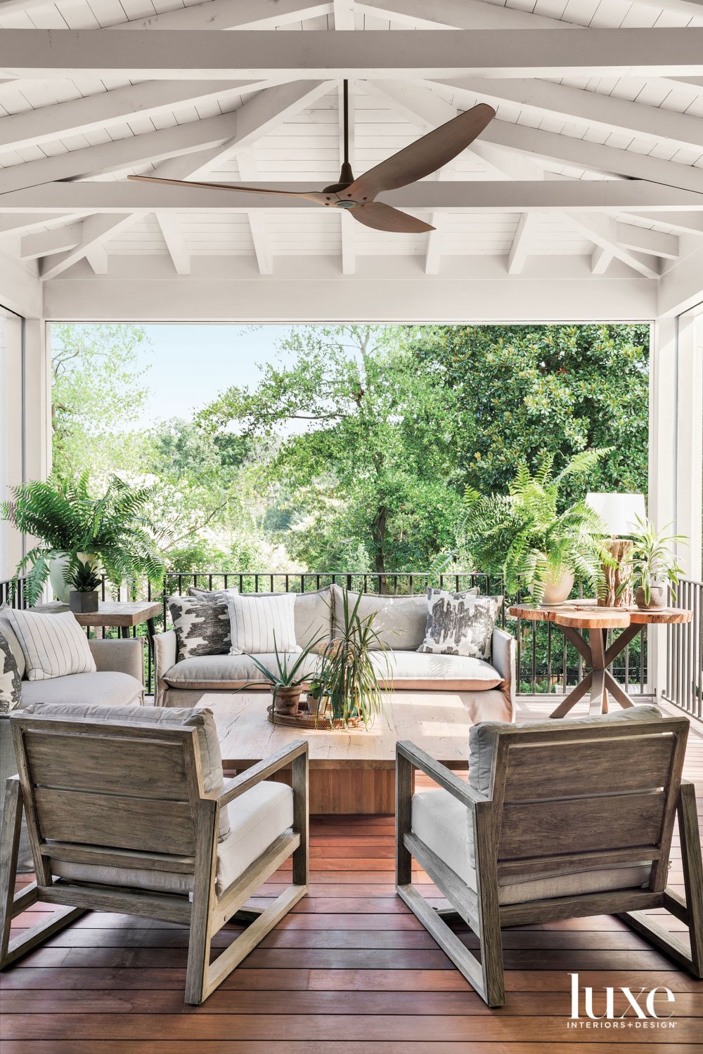 Covered porch with ceiling fan and green trees