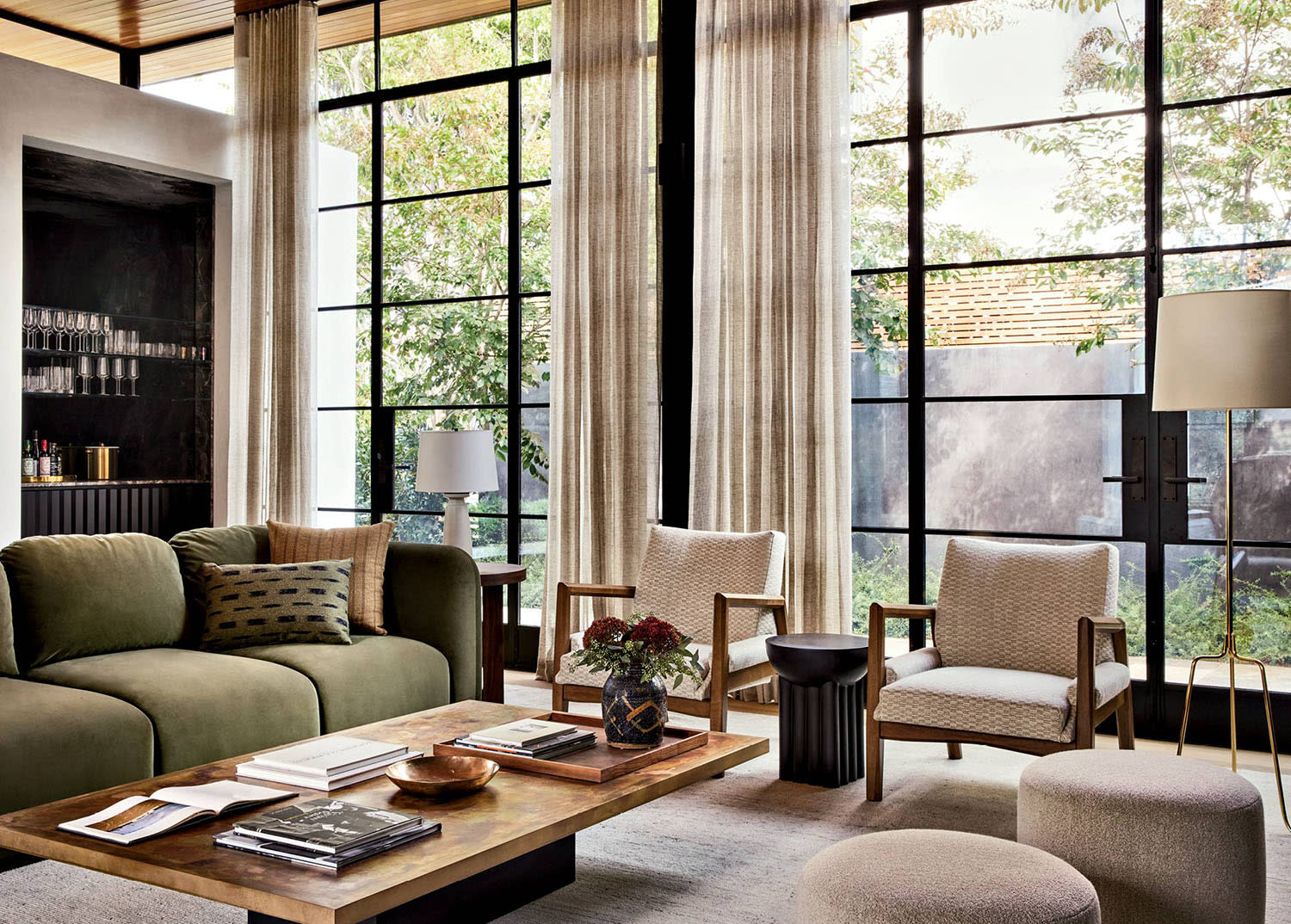 bright living room with windows lining one wall and a green sofa