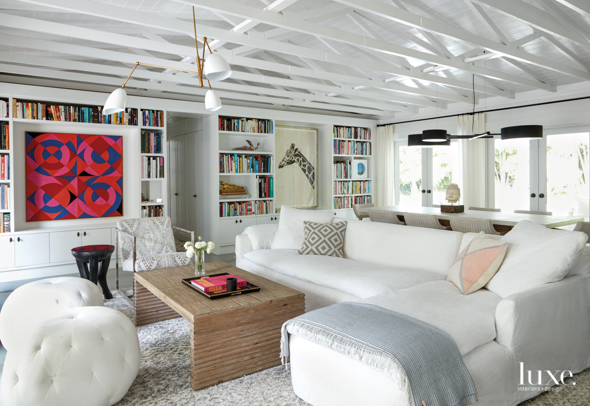 living room with white couch, ottoman and bookshelves