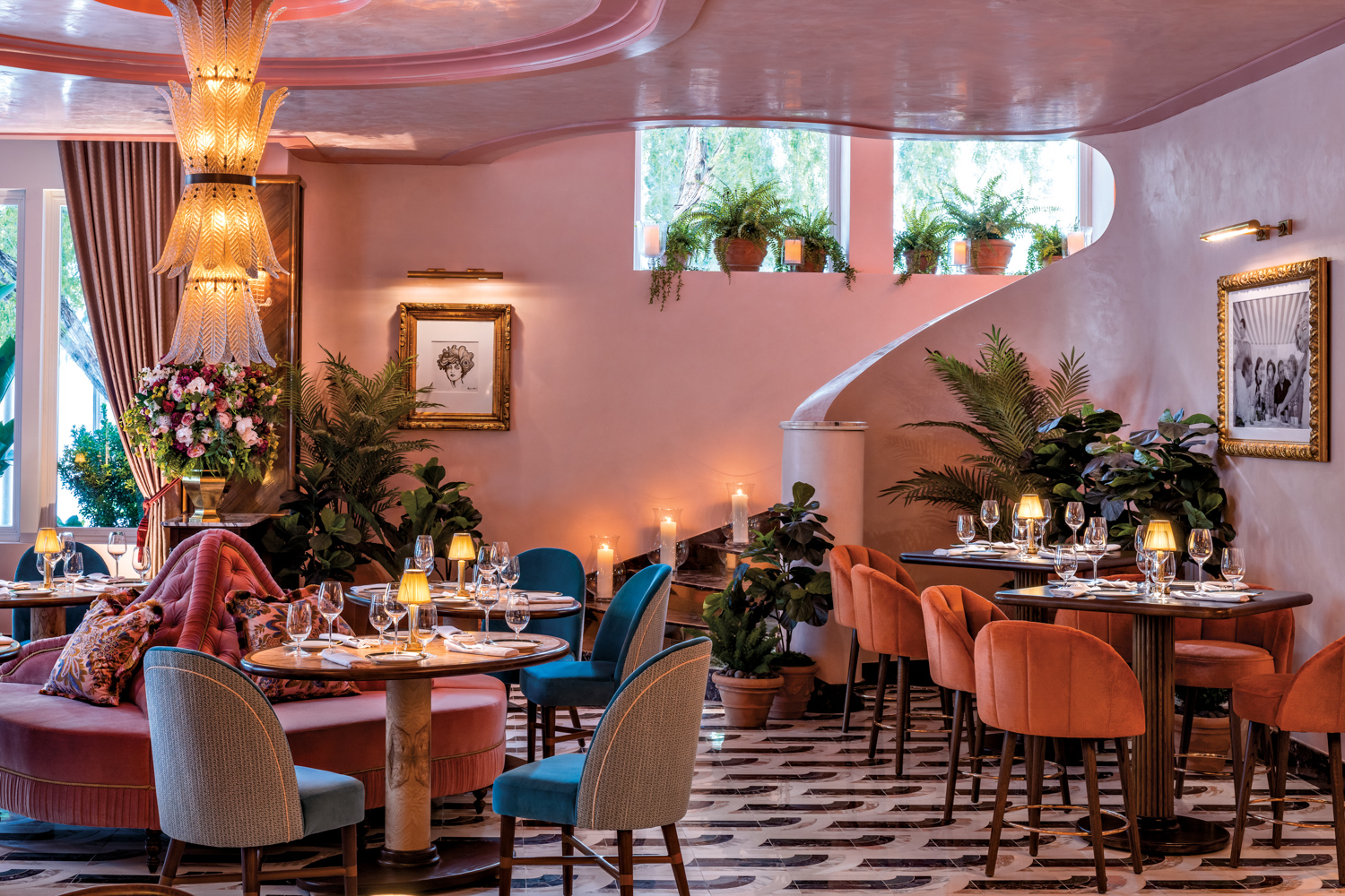 A Murano glass light fixture hangs from the pink Venetian plaster ceiling in a Miami restaurant