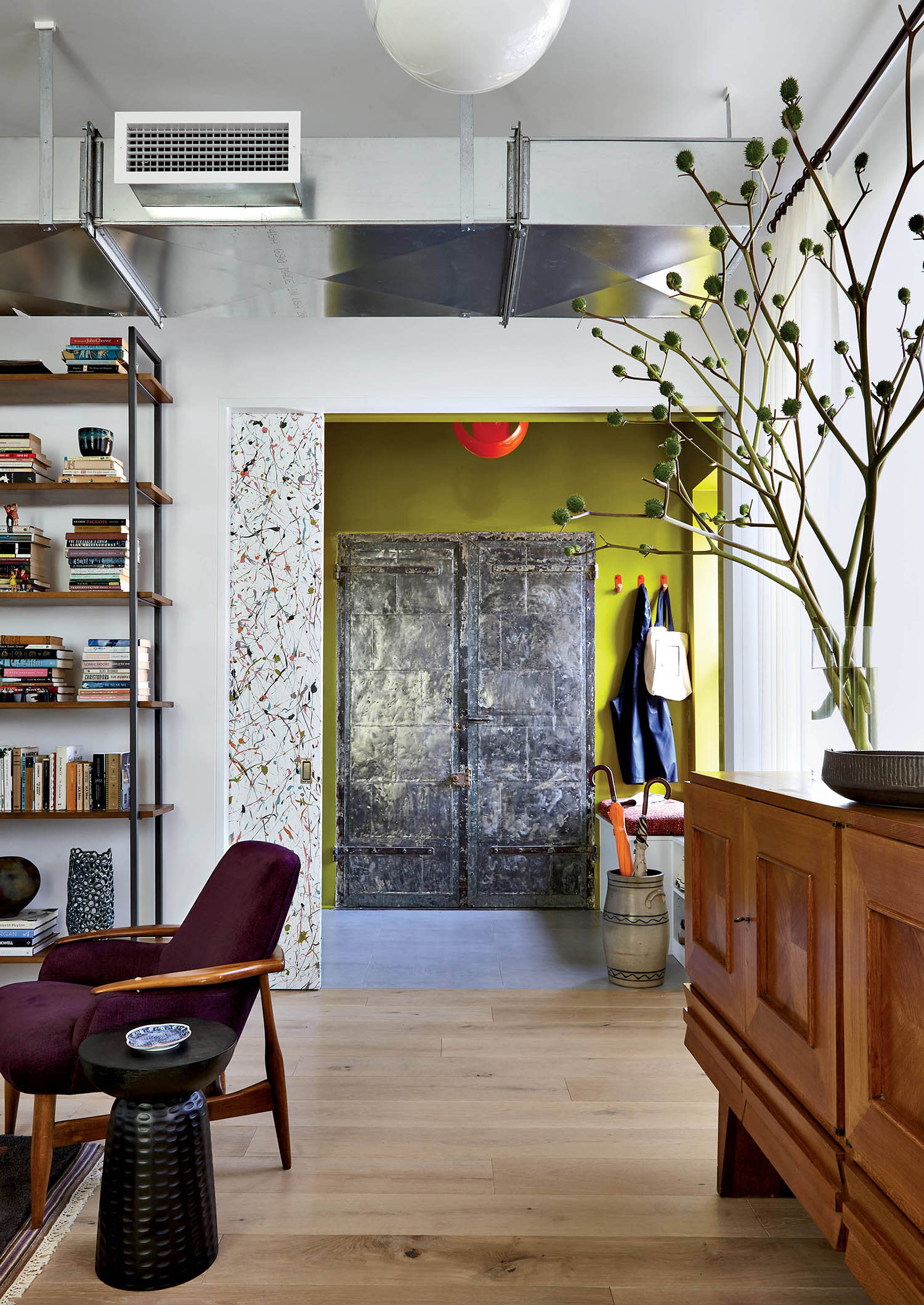 elevator vestibule features a chartreuse paint on the walls and a 1960s pendant by Carlo Nason