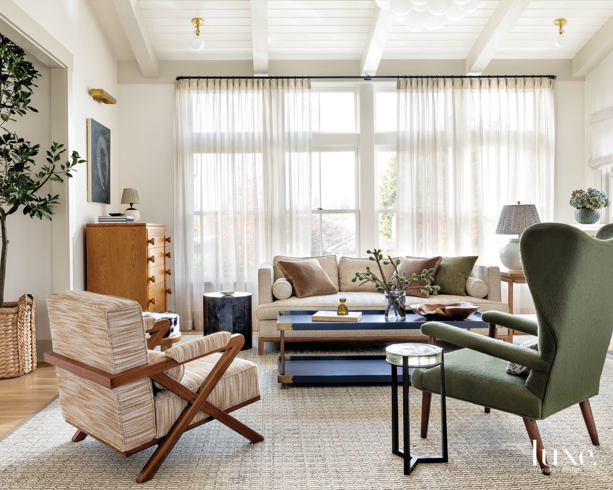 Living room with chairs, sofa and chest looking toward windows