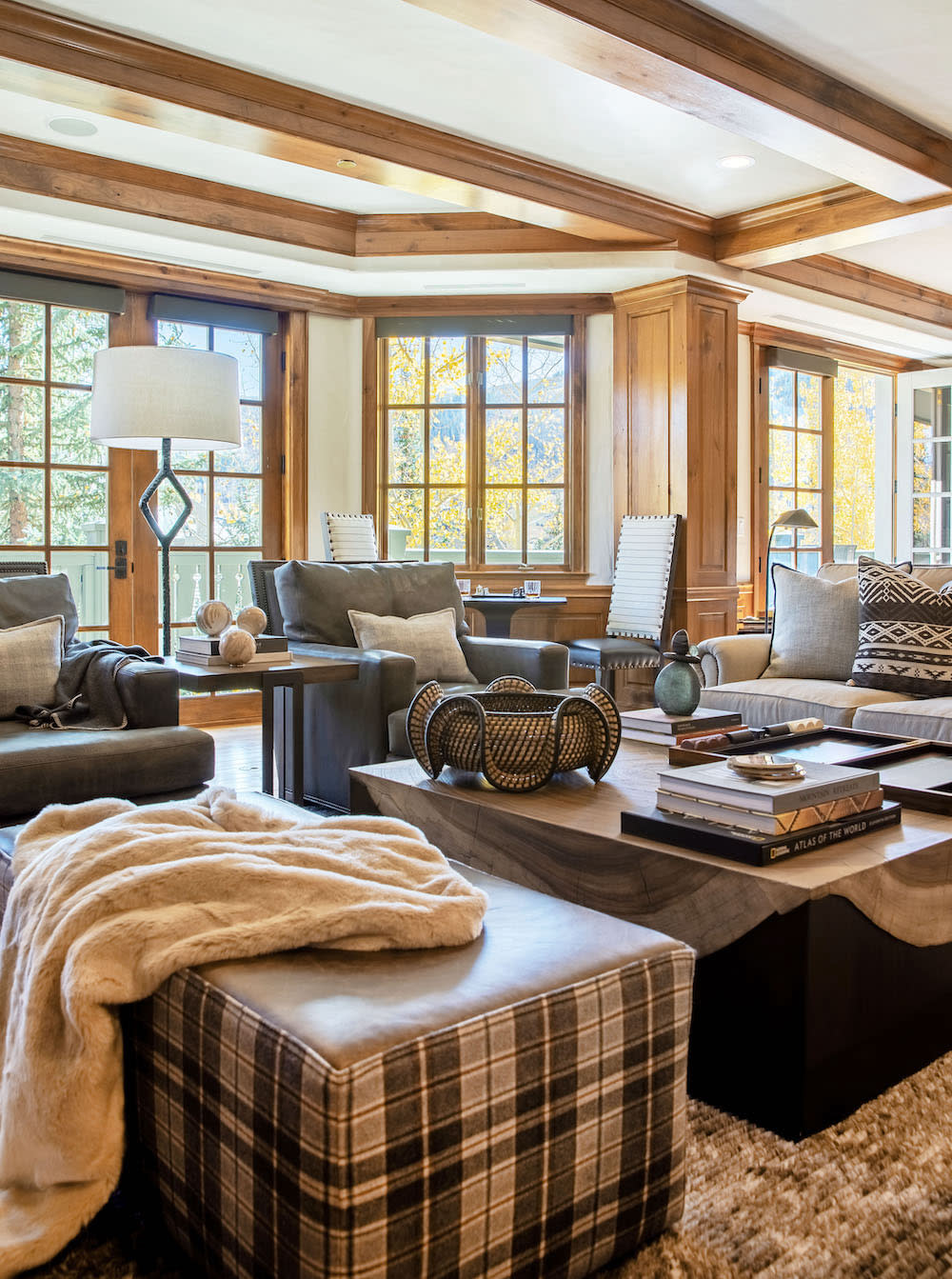 Media room with oversized chairs, plaid ottoman and space for games at the back of room