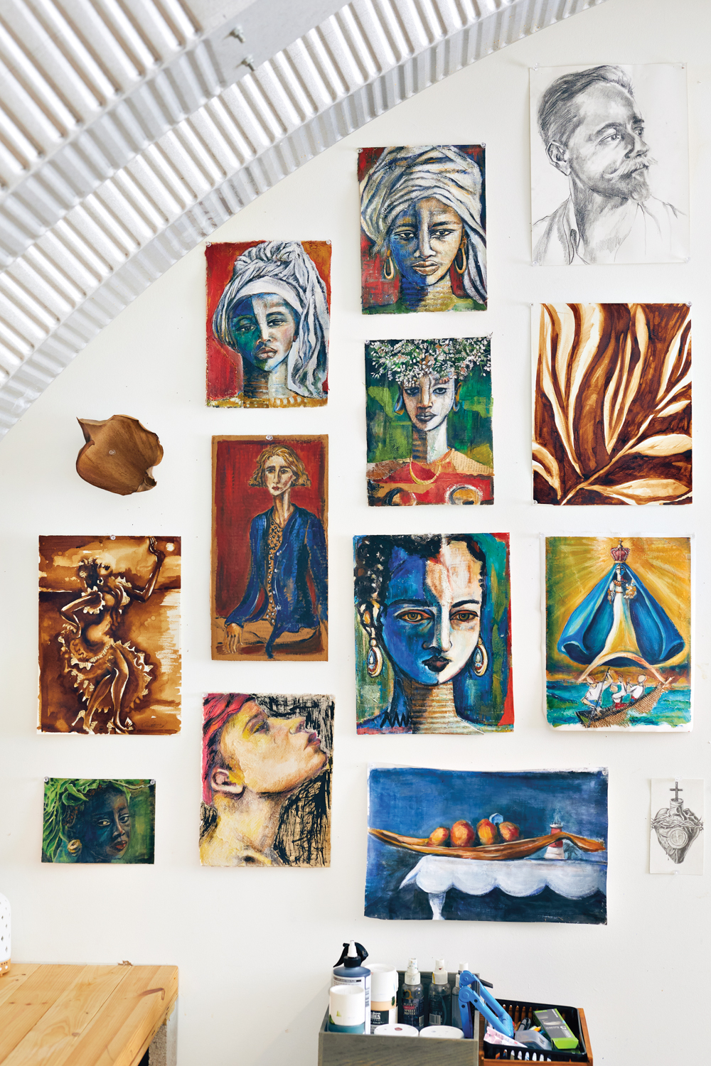 display of collaged portraits on wall of studio