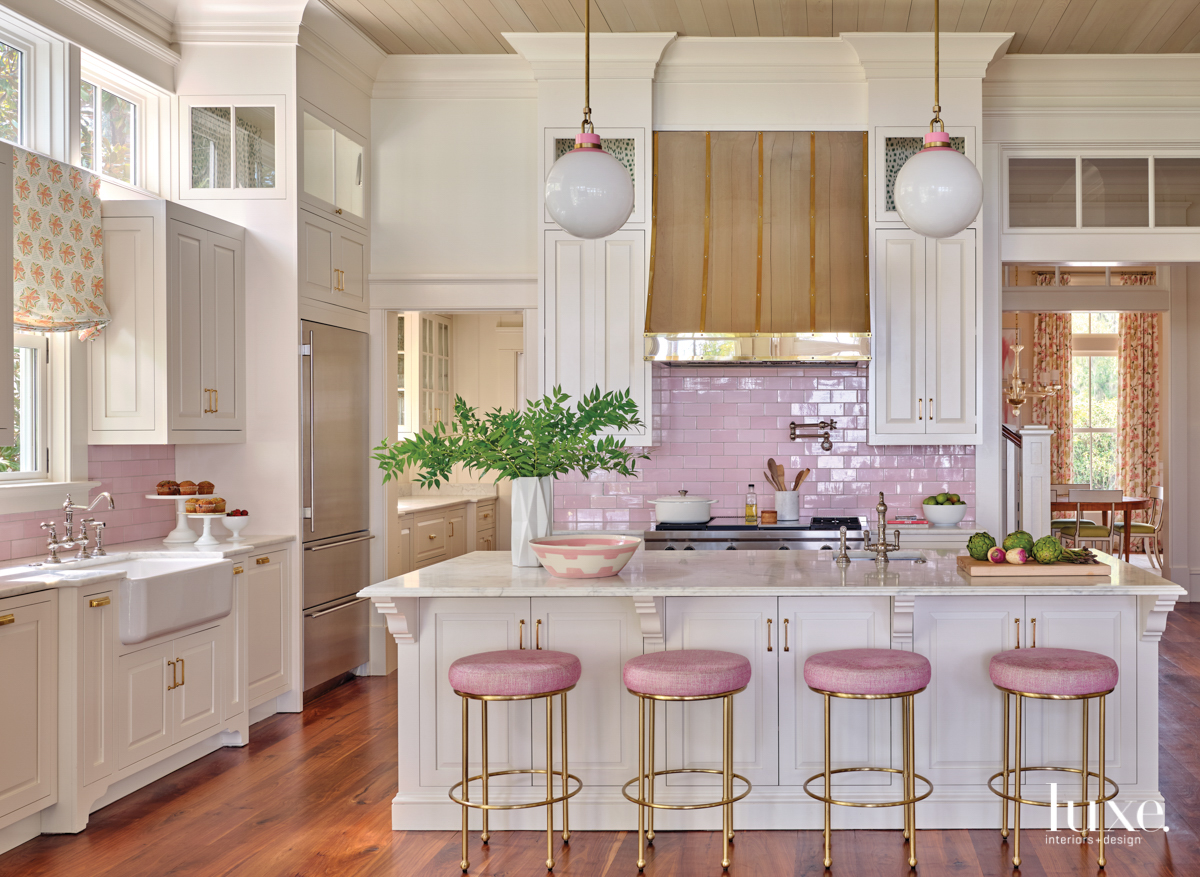 Barbiecore interior design kitchen with pink backsplash and brass hood