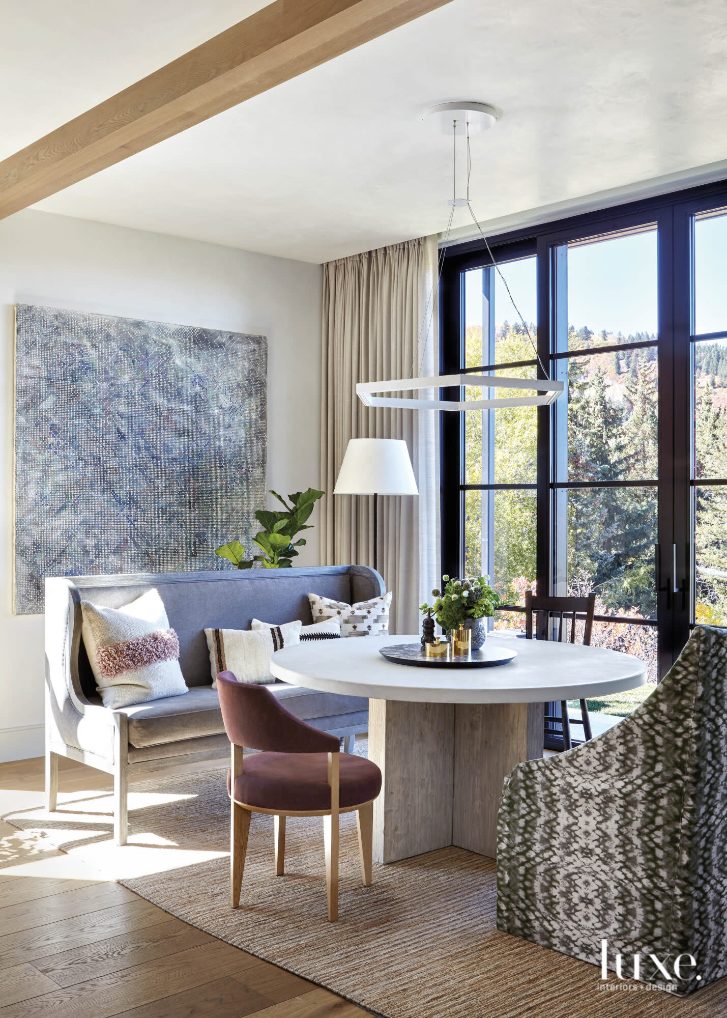 A kitchen eating area features art and a large window.