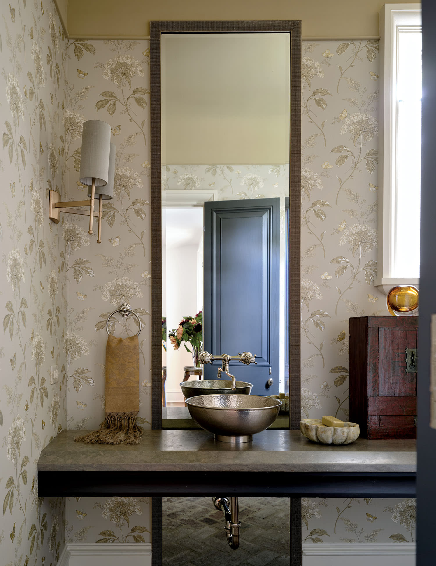 A clean bathroom featuring a sink and a mirror above it, reflecting the bright, well-lit space.