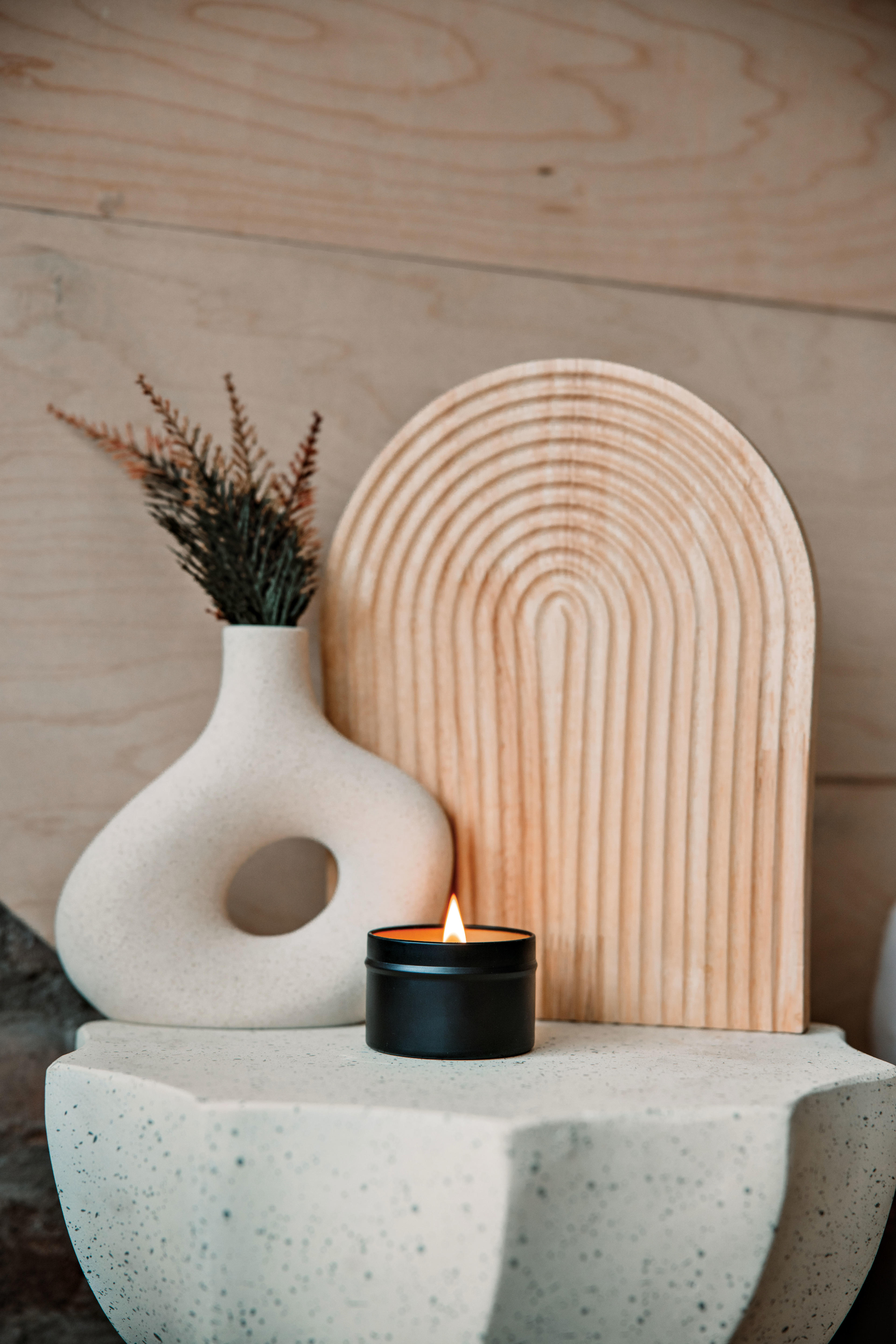 lit candle by Crackling Springs in front of a vase 