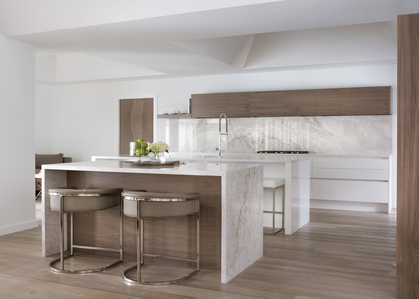 Seamless blend of warm wood cabinetry and softly veined stone surfaces. Clean lines, integrated storage, and a sculptural waterfall island create a calm, architectural space defined by balance, restraint, and refined materiality.
Photo by: Costa Christ
