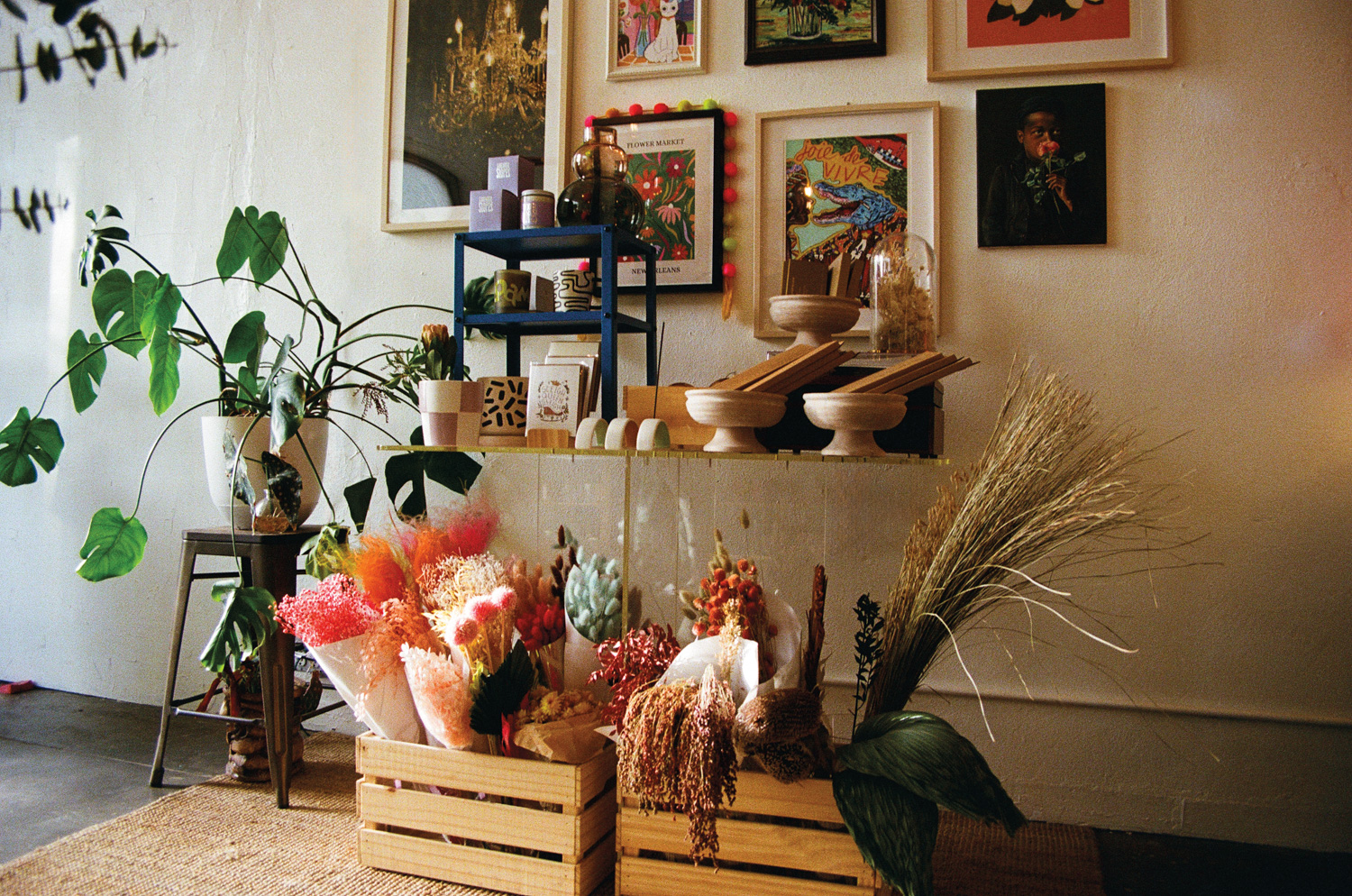 Flower shop with an assortment of dried flowers beneath a shelf with glass and ceramic vessels